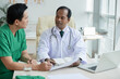 © DragonImages - Doctors discussing information in medical card of patient when trying to figure out diagnosis
