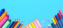 Wide Banner. Colorful Pencils, Felt-tip Pens, Brushes, Stickers And Stationery Flat Lay. School Office Supplies Lie From Below On Light Blue Background. Back To School And New Academic Year Concept.