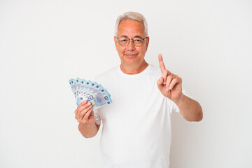 Senior american man holding bill isolated on white background showing number one with finger.