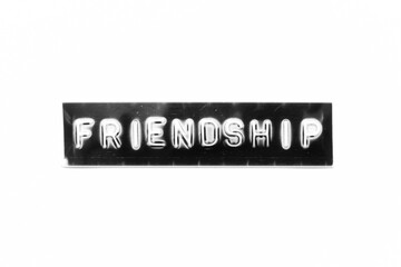 Poster - Embossed letter with word friendship in black banner on white paper background