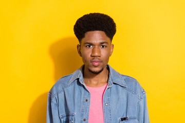 Photo of serious afro american young man wear denim shirt casual isolated on yellow color background