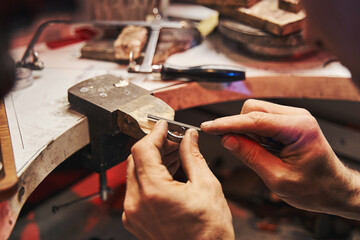 Jeweler is polishing workpiece with hand file