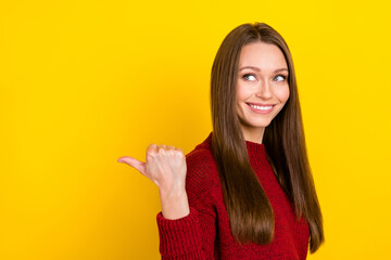 Portrait of attractive cheerful long-haired girl demonstrating copy blank space ad isolated over vibrant yellow color background