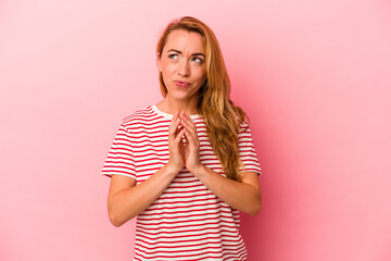 Caucasian blonde woman isolated on pink background making up plan in mind, setting up an idea.