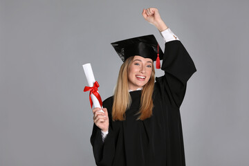 Wall Mural - Happy student with diploma on grey background