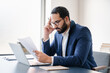 © InsideCreativeHouse - Concentrated tired stressed depressed serious arabian businessman having problems at workplace, solving job issues, doing paperwork. Deadline, paying bills, debt and loan concept. Headache migraine