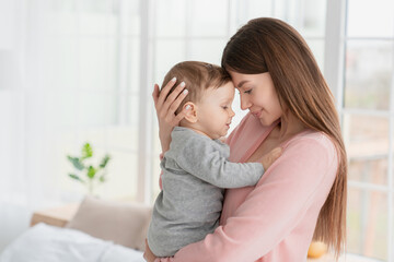 young mother hugging embracing little son daughter kid child with love and care. babysitter nanny ho