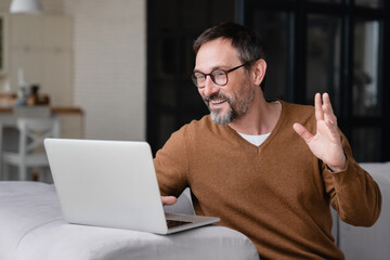 Happy mature middle-aged man businessman freelancer father having online video call conference conversation on laptop remotely with colleagues, friends, children, doctor`s appointment.