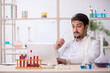 © Elnur - Young male chemist sitting at computer at the lab