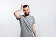 © Daria Lukoiko - Portrait of handsome young man frowning while holding hands near head on white background with space for advertising mock up