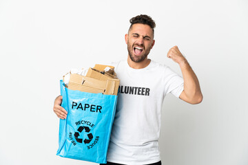 Caucasian man holding a recycling bag full of paper to recycle isolated on white background celebrating a victory