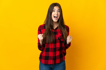 Teenager Brazilian girl isolated on yellow background celebrating a victory in winner position