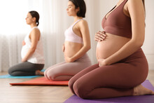 Group Of Pregnant Women Practicing Yoga In Gym, Closeup
