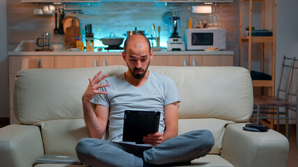 Poster - Focused man having online meeting videocall on tablet computer speaking using videoconference online web internet communication. Caucasian man browsing on internet for deadline project