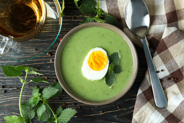 Concept of healthy food with nettle soup on wooden table