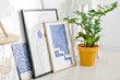 © Pixel-Shot - Stylish pictures and houseplant near light wall