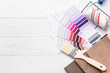 © Pixel-Shot - Composition with paint color palettes and fabric samples on white wooden background