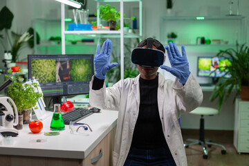 African scientist biologist conducting research using virtual reality doing hand gesture for agronomy looking at sample. Medical team working in pharmaceutical laboratory analyzing dna test.