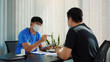© wutzkoh - Doctors are explaining the treatment of a sick patient in tablets while wearing a mask during the virus outbreak.