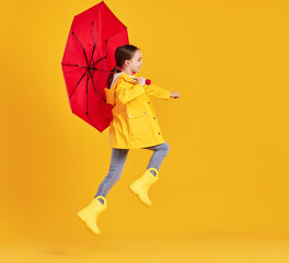 Happy kid with umbrella jumping in studio