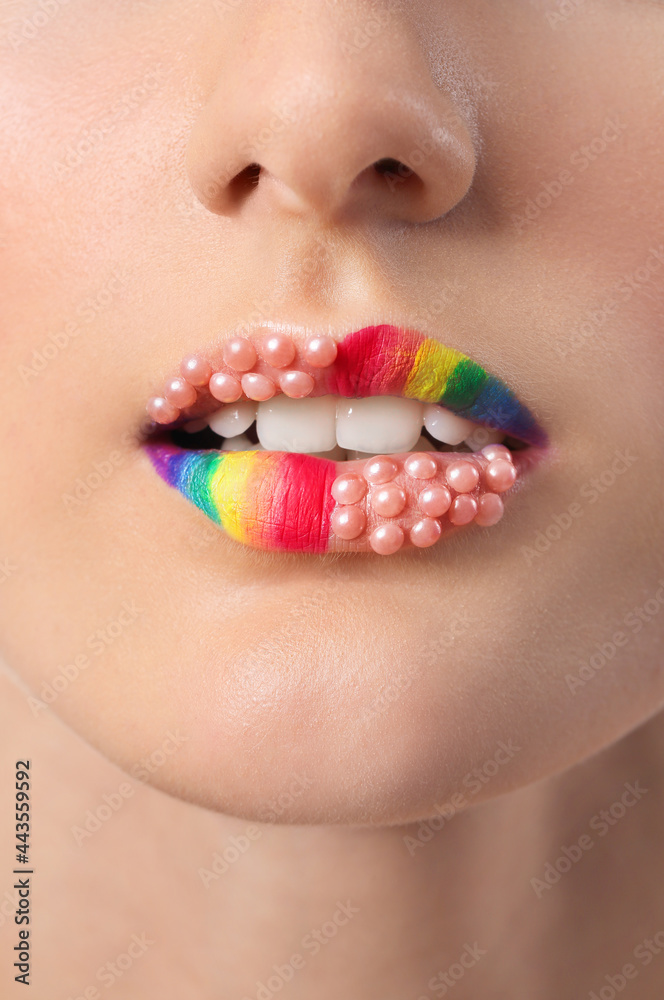 Beautiful young woman with rainbow lips, closeup