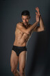 © qunica.com - Fashion close-up portrait of a handsome male with bare torso posing in black underwear on isolated background