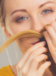 Woman making moustache out of blonde hair