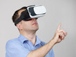 Man wearing virtual reality goggles on grey