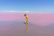 little girl happy and rejoices in pink water in a salt lake