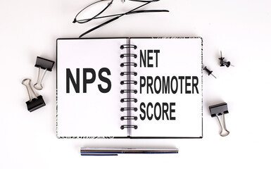 Poster - Notebook with text NPS NET PROMOTER SCORE on a table