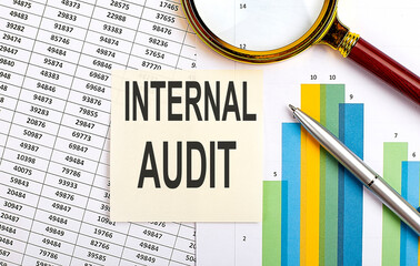 Poster - Business concept. Top view of stiscker with text INTERNAL AUDIT on chart background