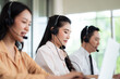 © SEVENNINE_79 - Team of call center staff in Asia wears headphones with a microphone. Smile while serving customers at desks and computers. Service concept and consulting. Communication concept.