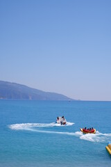 Wall Mural - Mugla , Turkey - June 18th 2021 : tourists enjoying extreme sea sport with view of Oludeniz sea 