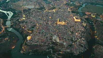 Sticker - Drone point of view old town of Toledo at dusk. Illuminated townscape view from above, Tagus river, picturesque scenery. Castilla la Mancha, Madrid, Spain. Famous places and landmark, travel concept