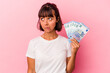 © Asier - Young mixed race woman holding bills isolated on pink background confused, feels doubtful and unsure.