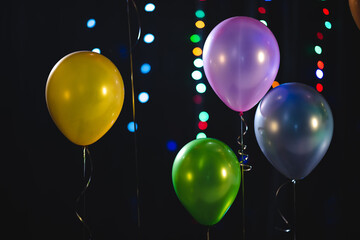 colorful balloon decoration for party, celebration new year eve. christmas party, balloon in black background, helium balloons, orange green blue and purple.