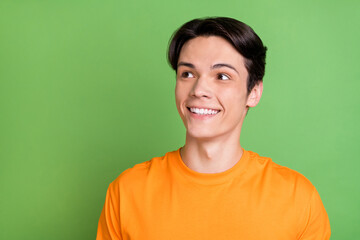 Sticker - Photo of young happy cheerful positive man look empty space smile curious isolated on green color background