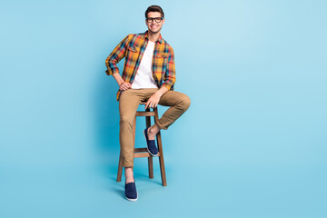 Sticker - Photo of attractive cute gentleman wear checkered shirt arm glasses sitting bar chair empty space isolated blue color background