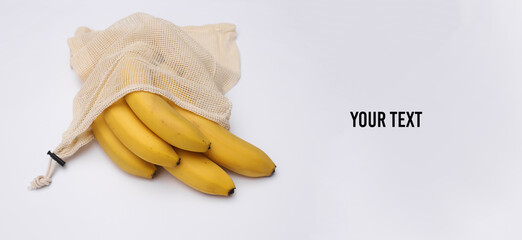 Eco cotton bag with ripe bananas on white background. Copy space