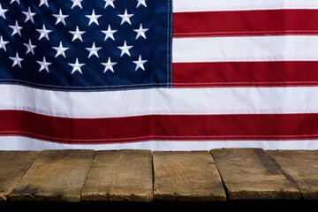 Wall Mural - Rustic empty wooden table top with USA United States of America flag on background.