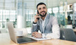 Smiling businessman talking on smartphone in modern office