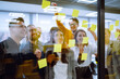 © maxbelchenko - Sharing ideas concepts with papernote writing strategy on wall glass office. Business people meeting at office and use post it notes to share idea. Brainstorming concept. Planning, education, analysis