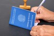 © Brenda Blossom - Person signing a Brazilian work card (carteira de trabalho). Employee hiring concept.