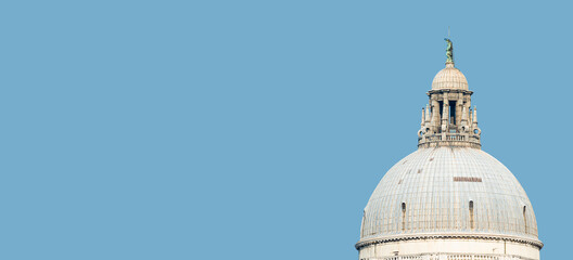 Banner with Basilica di Santa Maria della Salute, its top dome with statue of Saint Monk and observation balcony terrace in Venice, Italy, with copy space blue sky solid background