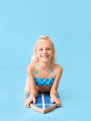 Wall Mural - Cute little girl with surfboard on color background