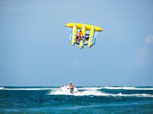Flying Fish Water Sport Activity In Tanjung Benoa, Bali, Indonesia. Popular Tourist Attraction. Clear Blue Sky With Horizon In Background.