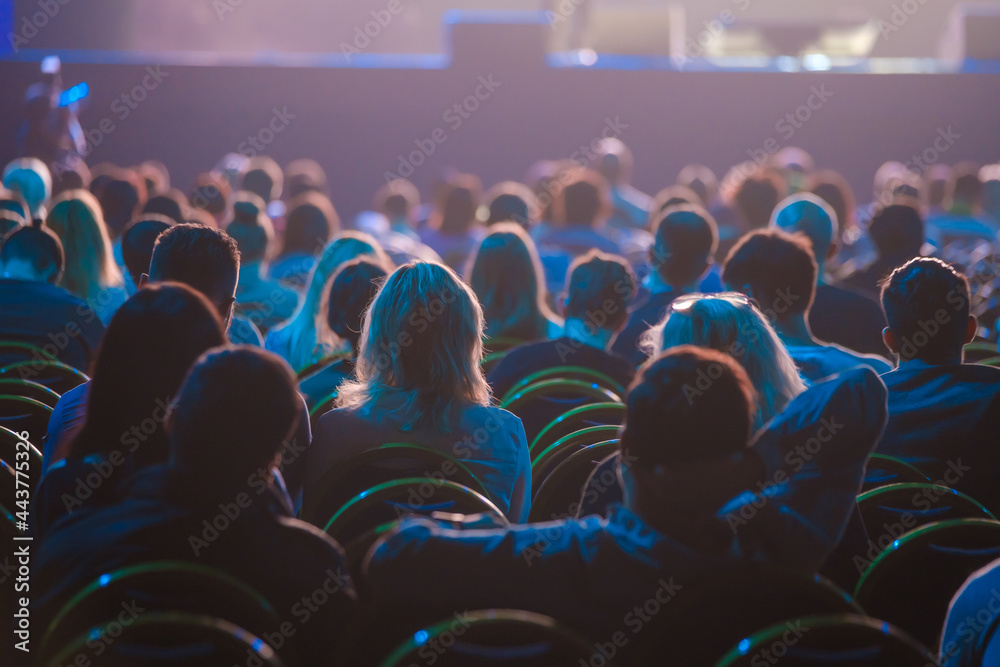 Unrecognizable people sitting in dark auditorium - obrazy, fototapety, plakaty 