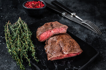 Wall Mural - Grilled Top Blade or flat iron roast beef meat steaks on marble board. Black background. Top View