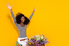 Photo Portrait Of Curly Woman Riding A Bike Enjoying Fresh Wind Keeping Hands Up Crazy Isolated Vivid Yellow Color Background
