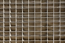 The Light Or Bright Grey Urban Background Or Backdrop Of New Concrete Building Construction In The Rays Of Midday Sun With Many Lines, Squares And Rectangles Like Grid, Grid Or Grate Structure